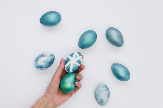 Flat lay of hand holding dyed eggs for easter