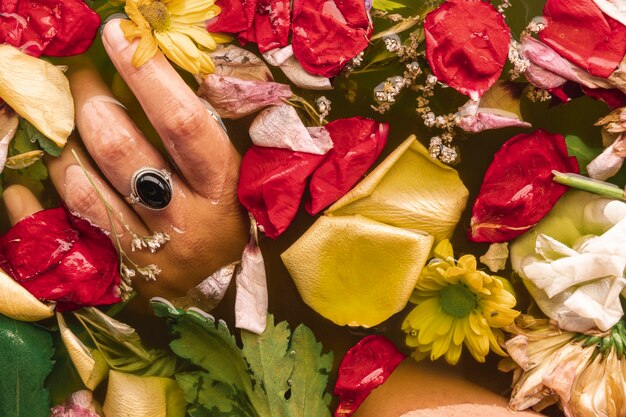 Flat lay hand holding flowers in black water