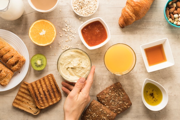 Free photo flat lay hand holding hummus bowl