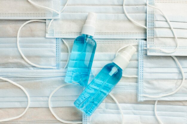 Flat lay of hand sanitizer bottles on medical masks