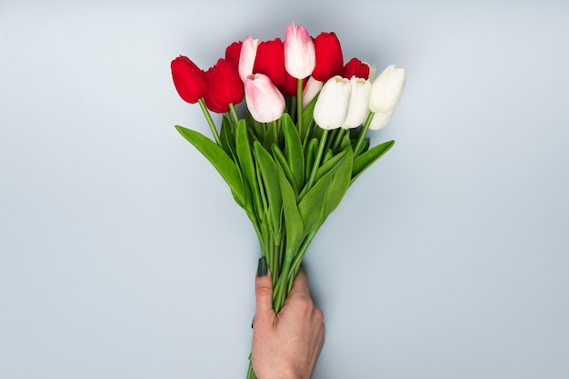 Flat lay hand with tulips bouquet