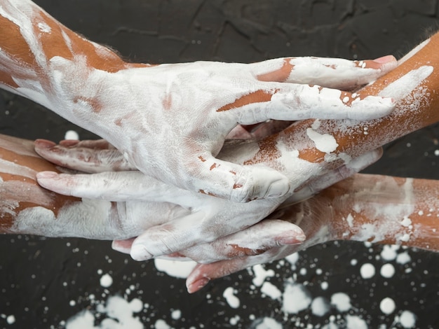 Free photo flat lay of hands covered in white paint