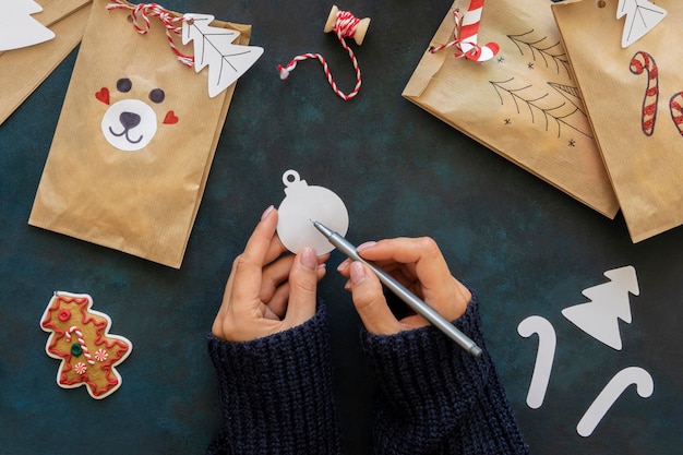 Flat lay of hands decorating christmas gift bags
