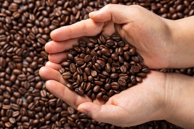 Flat lay hands holding coffee beans