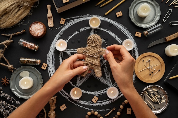 Free photo flat lay hands holding voodoo doll