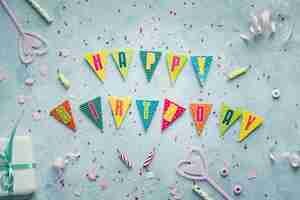 Free photo flat lay of happy birthday wish in garland with present