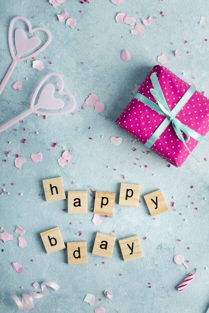 Flat lay of happy birthday wish in wooden letters and present