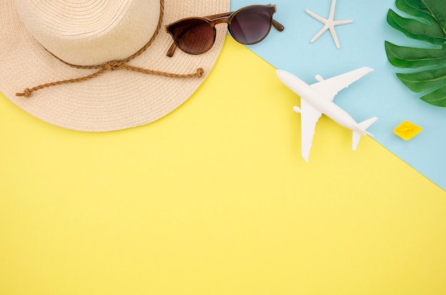 Flat lay of hat and glasses on yellow background