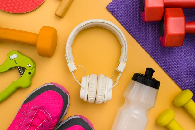 Flat lay of headphones with weights and sneakers