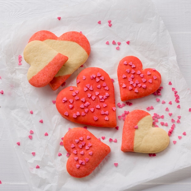 Foto gratuita disposizione piana dei biscotti a forma di cuore su carta
