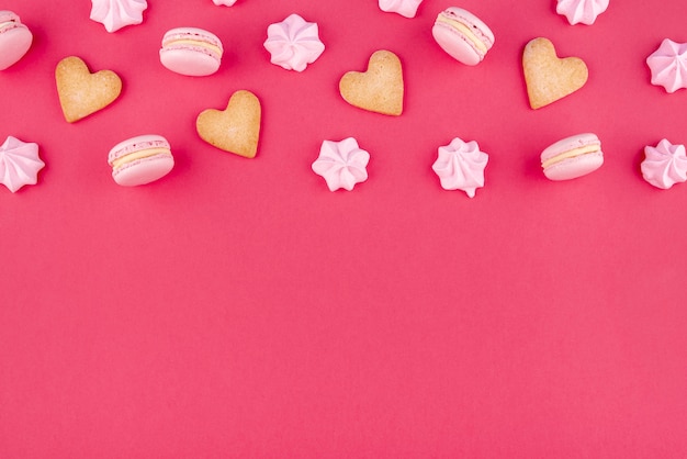 Flat lay of heart-shaped cookies with macarons and meringue