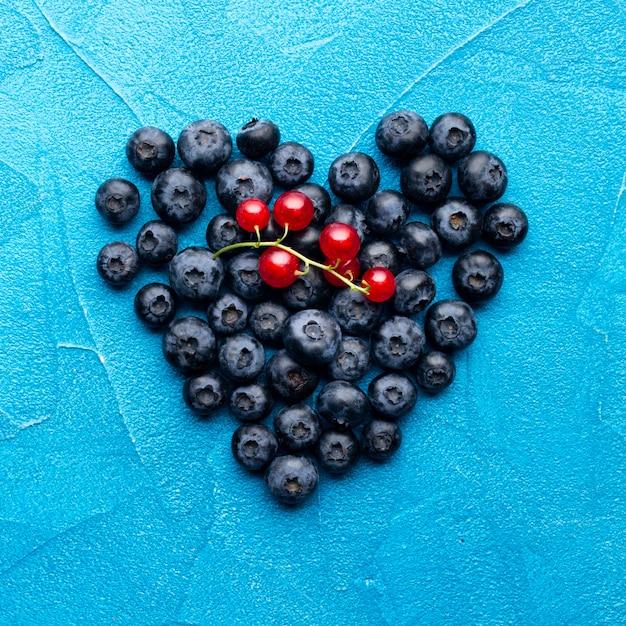 Flat-lay heartshaped blueberries and redcurrants