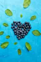 Free photo flat-lay heartshaped currants with leaves