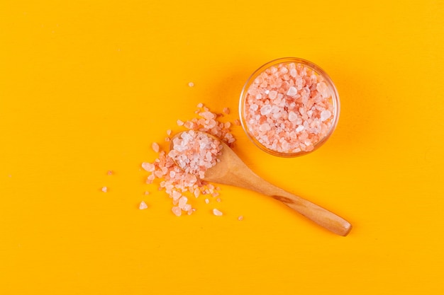 Flat lay himalayan salt in small bowl with wooden spoon
