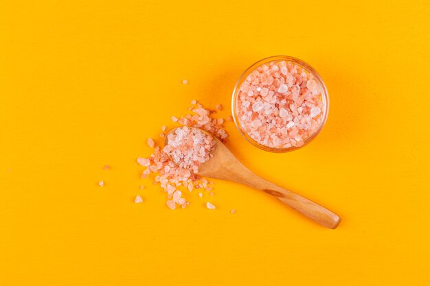 Flat lay himalayan salt in small bowl with wooden spoon