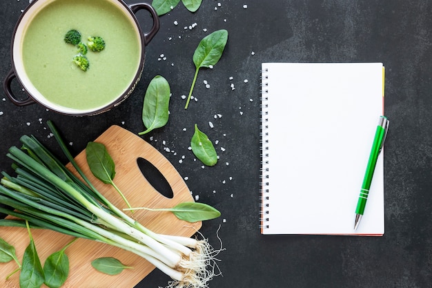 Free photo flat lay homemade soup of broccoli and notepad