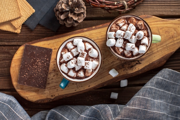 Flat lay hot chocolates with marshmallows and chocolate tablet