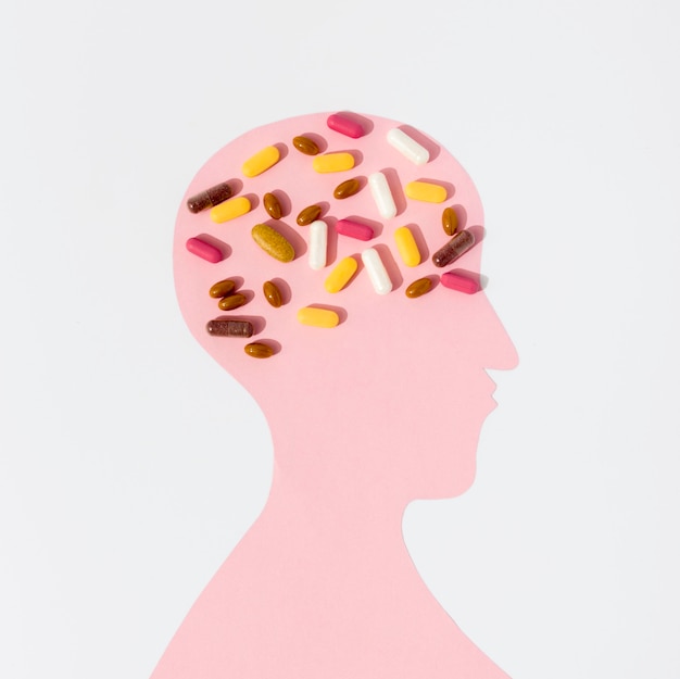 Free photo flat lay of human shape with lots of pills on brain