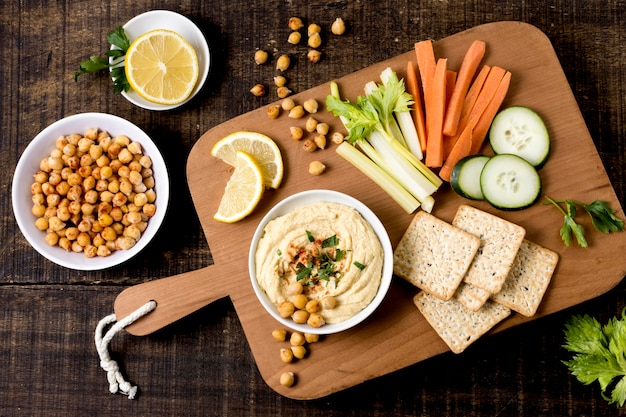 Flat lay of hummus with assortment of vegetables