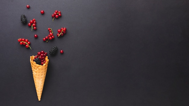 Flat-lay ice cream cone with berries with copy space