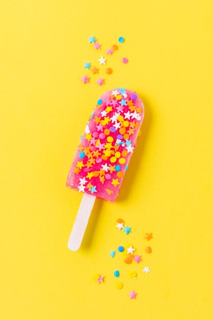 Flat lay ice cream on stick with candies