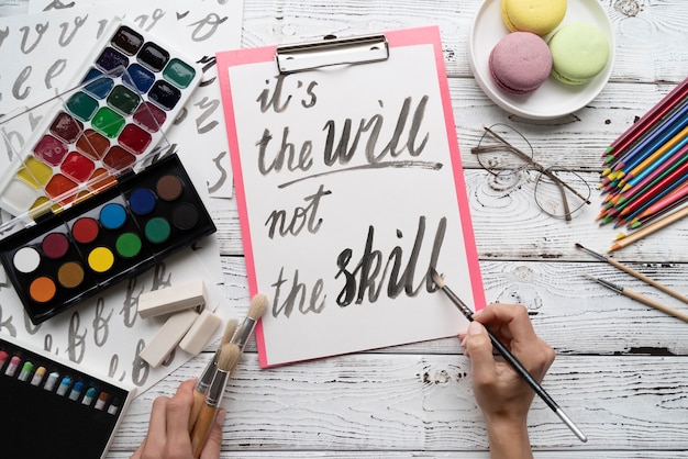 Flat lay of it's the will not the skill inspirational quote on notepad with color palette