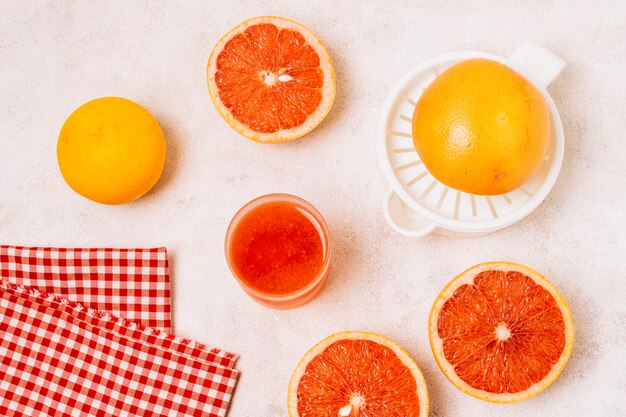 Flat lay juicer next to halved grapefruits 