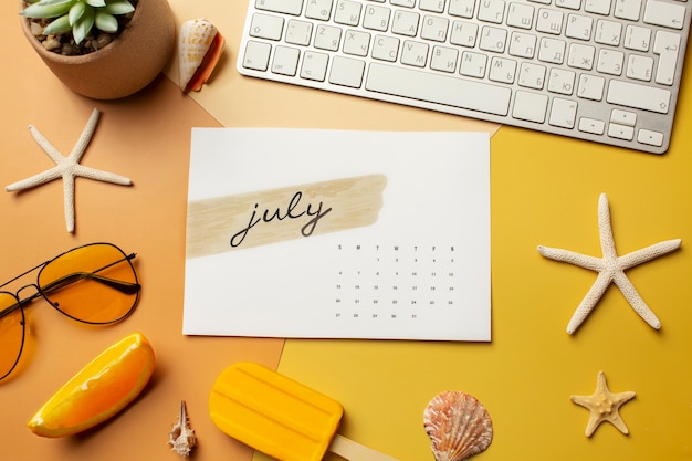 Flat lay july calendar and keyboard