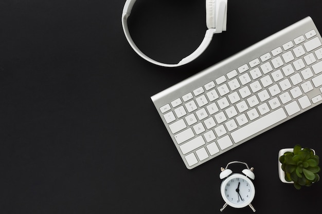 Flat lay of keyboard and headphones on desktop