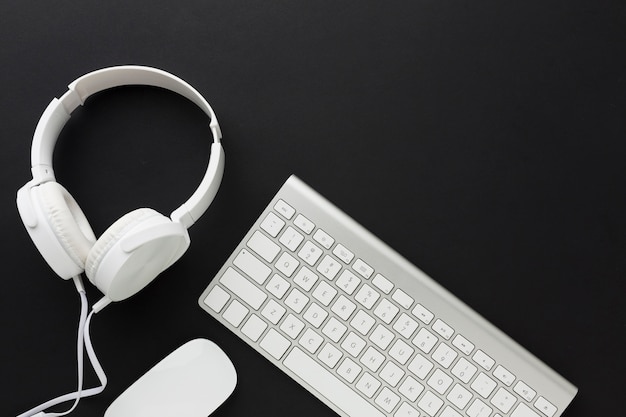 Flat lay of keyboard and headphones with copy space