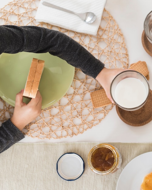 Foto gratuita ragazzo piatto laico facendo colazione