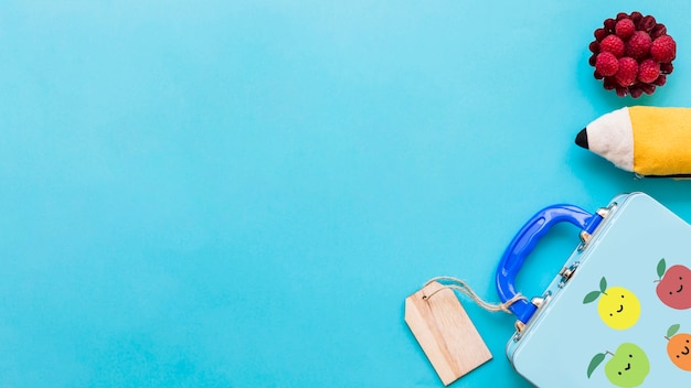 Flat lay of kid school details on turquoise surface