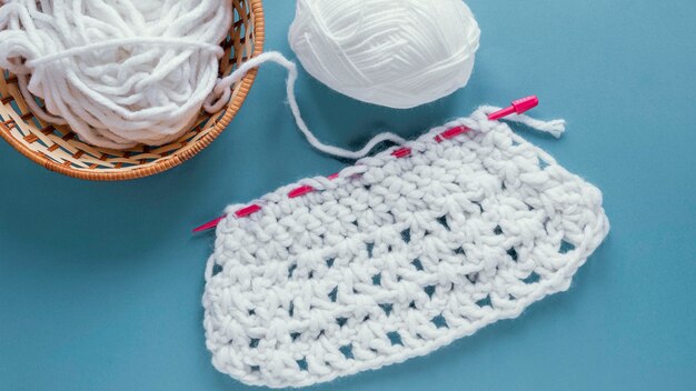 Flat lay knitting needles and wool in basket