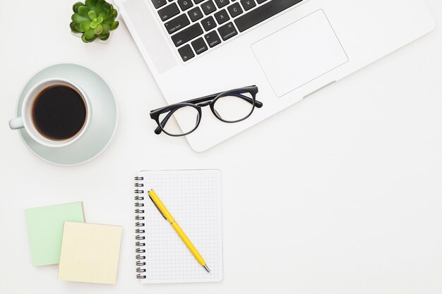 Flat lay laptop mockup with notepad