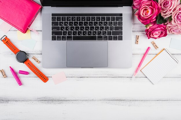 Flat lay laptop with bouquet of pink roses