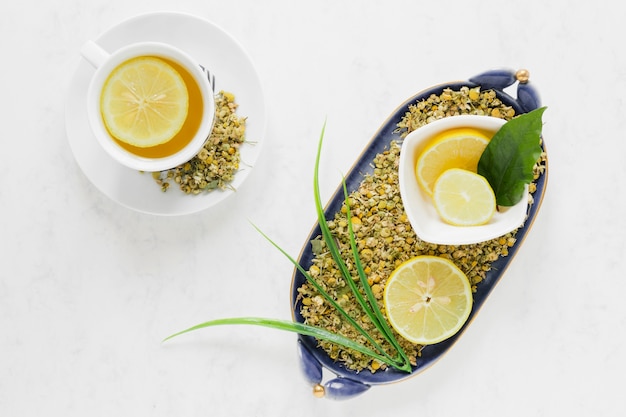 Foto gratuita piatto disteso di tè al limone e foglie ciotola