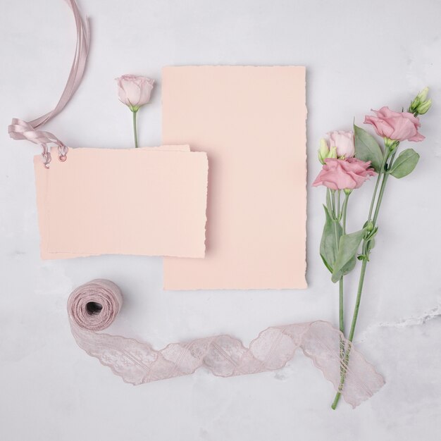 Flat lay lovely arrangement with wedding invitations and flowers