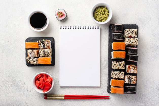 Flat lay maki sushi rolls assortment with blank notebook