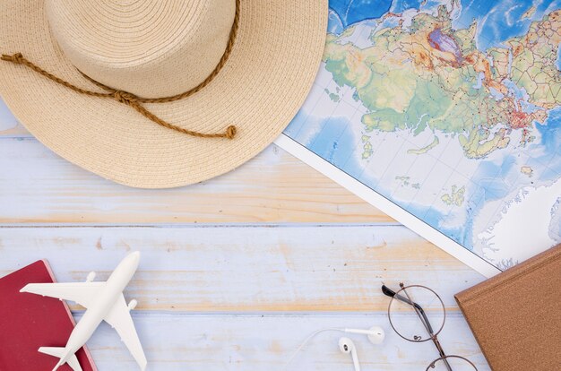 Flat lay of map and hat on wooden table