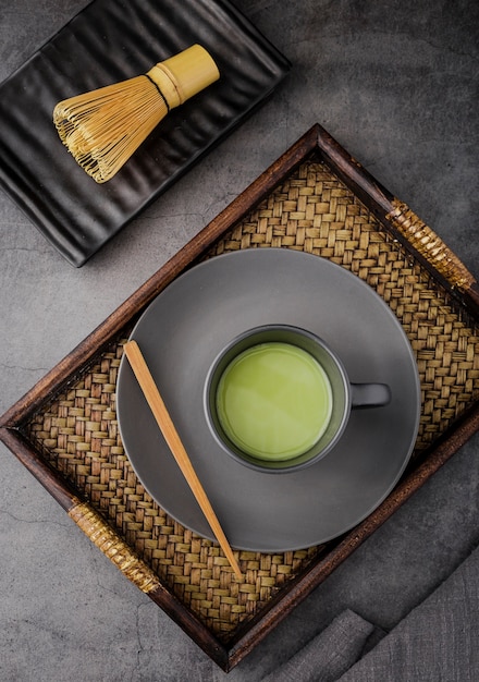 Disposizione piana della tazza di tè di matcha sul vassoio