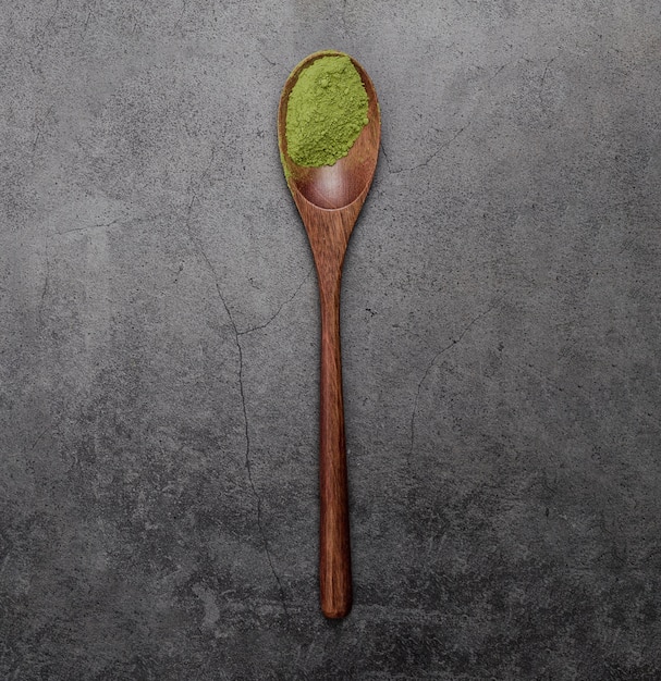 Disposizione piana della polvere del tè di matcha in cucchiaio di legno