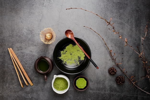 Flat lay of matcha tea with wooden spoon and branches