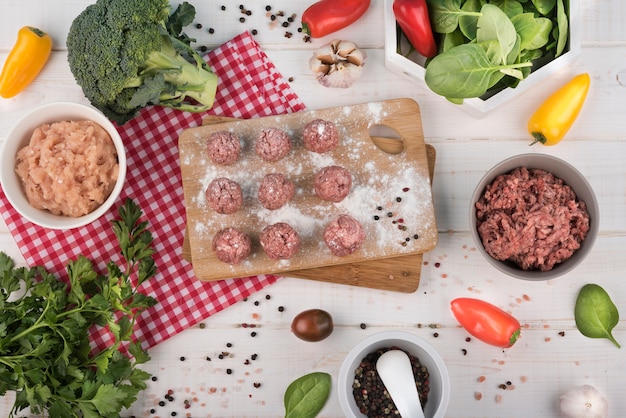 Free photo flat lay meatballs on wooden board, minced meat and broccoli