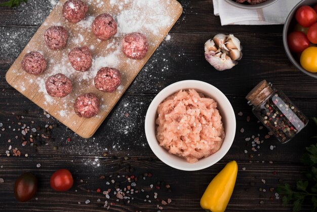 Flat lay meatballs on wooden board and minced meat