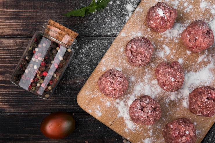 Free Photo flat lay meatballs on wooden board with pepper