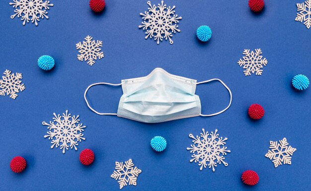 Flat lay medical mask and snowflakes