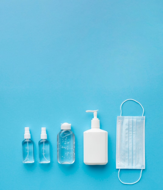 Flat lay of medical mask with hand sanitizer and copy space