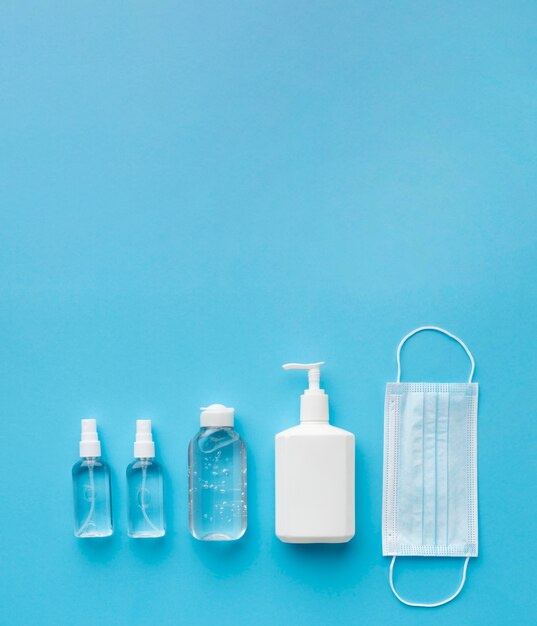 Flat lay of medical mask with hand sanitizer and copy space