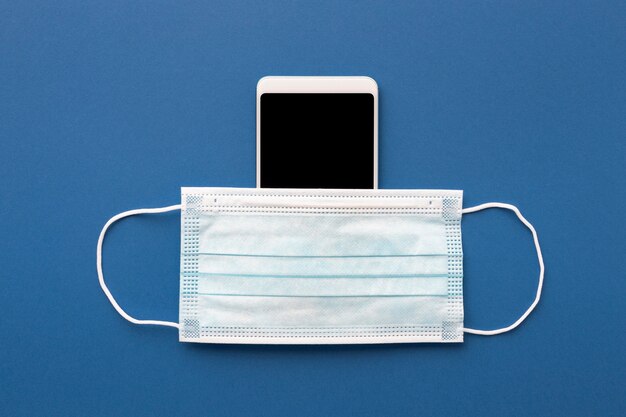 Flat lay of medical mask with smartphone