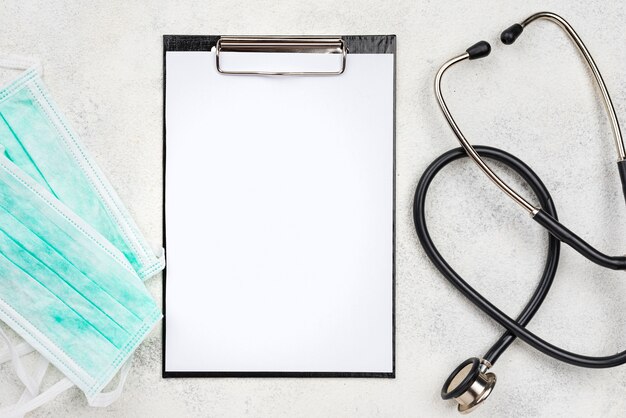 Flat lay medical objects arrangement with empty clipboard